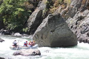 A group of rafters navigating a Class IV rapid